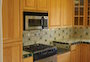 View to kitchen from dining room; with Dacor range and custom cabinetry.